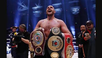 Tyson Fury posa con los tres cinturones de campe&oacute;n de los pesos pesados.