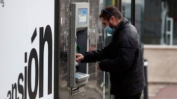 MADRID, 07/04/2020.- Un hombre saca dinero de un cajero este martes, vigésima cuarta jornada desde que se decretase el estado de alarma para frenar la epidemia del coronavirus. EFE/Mariscal