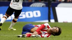 Jo&atilde;o F&eacute;lix llev&aacute;ndose las manos a su tobillo derecho con gesto de dolor en el partido ante el Valencia del Atl&eacute;tico en la 2020-21. Hoy se operar&aacute; de &eacute;ste.