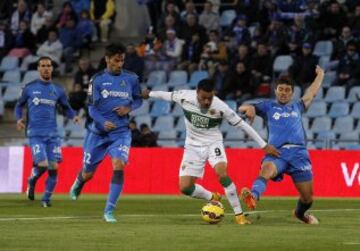 El centrocampista del Getafe Juan Rodríguez (i) lucha un balón con el delantero del Elche Cristian Herrera, durante el partido correspondiente a la undécima jornada de Liga de Primera división que disputan en el estadio Coliseum Alfonso Pérez. 