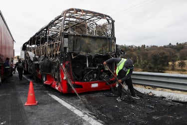 Un autobús incendiado se encuentra en la carretera que conecta la Ciudad de México con el estado de Puebla, tras los bloqueos y ataques incendiarios perpetrados por miembros del crimen organizado en varios estados. 