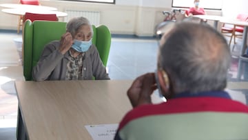 Un anciana residente recibe a un familiar durante la pandemia.