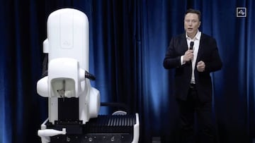 This video grab made from the online Neuralink livestream shows Elon Musk standing next to the surgical robot during his Neuralink presentation on August 28, 2020. - Futurist entrepreneur Elon Musk late August 28 demonstrated progress made by his Neuralin