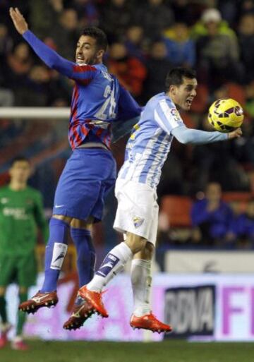 El centrocampista del Levante Camarasa salta a por un balón con Juanmi, del Málaga.