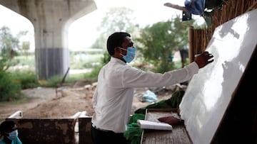Satyendra Pal, a college student, conducts an open-air class for the students of 9th class from a slum area, who do not have access to internet facilities and miss their online lessons, after authorities closed all the schools in March following the outbr