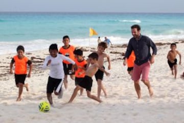 El futbolista español del Manchester United y de la selección española, Juan Mata, jugando al fútbol con niños en la playa en Cancún. La presencia del famoso futbolista forma parte de un programa para promocionar a Cancún como un destino turístico-deportivo