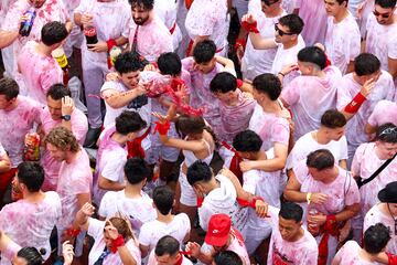 Personas se reúnen para celebrar durante el "Chupinazo", que marca el inicio oficial de las Fiestas de San Fermín en la Plaza Consistorial, frente al Ayuntamiento de Pamplona