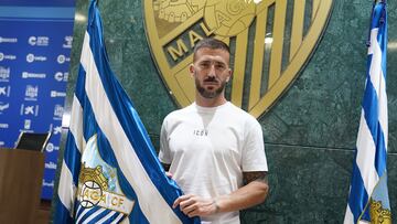 Dioni posa junto a la bandera del Málaga CF.