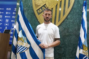 Dioni posa junto a la bandera del Málaga en su presentacion.