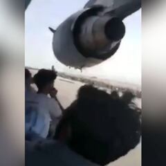 Afghans cling to side of plane as it prepares to take off in Kabul