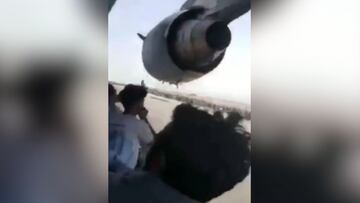 Afghans cling to side of plane as it prepares to take off in Kabul