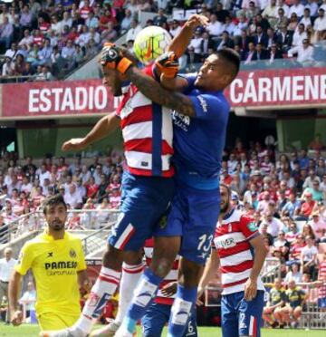 El delantero del Granada, El Arabi (i), intenta un remate con el portero del Villarreal Areola (d) durante el partido correspondiente a la tercera jornada de Liga entre el Granada y el Villarreal, disputado hoy en el estadio Nuevo Los Cármenes de Granada.