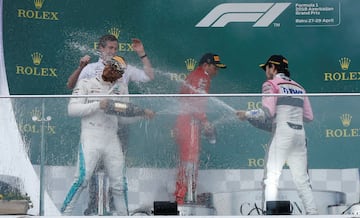 Lewis Hamilton, Sergio Pérez  Kimi Raikkonen  se bañan en champaña.