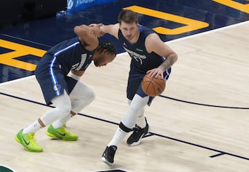 Luka Doncic (77) of the Dallas Mavericks helps up teammate Jalen Brunson (13).
