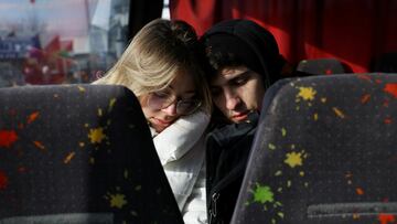 Dos jóvenes, visiblemente agotados, descansan en uno de los autobuses que cruzan la frontera de Ucrania con Polonia en Medyka.