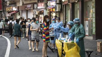 Healthcare workers in protective gear assist residents taking Covid-19 tests in Shanghai, China, on Tuesday, July 19, 2022. New Covid-19 cases in China jumped to almost 700, with more infectious strains of the virus continuing to test the country's hardline approach as outbreaks spread beyond the major cities. Photographer: Qilai Shen/Bloomberg via Getty Images