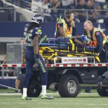 Ricardo Lockette, wide receiver de Seattle Seahawks, abandonando el campo con el brazo en alto, ante la mirada de Sherman.