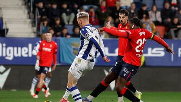 PAMPLONA, 02/02/2025.- El delantero islandés de la Real Sociedad, Orri Oskarsson (i), remata ante el defensa camerunés de Osasuna, Enzo Boyomo, consiguiendo el primer gol del equipo donostiarra durante el encuentro correspondiente a la jornada 22 de Laliga EA Sports que disputan hoy domingo Osasuna y Real Sociedad en el estadio El Sadar de Pamplona. EFE / Villar López.