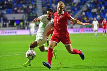 El jugador de Arabia Saudí Salem Al-Dawsari lucha un balón con el jugador del Líbano Robert Melki.