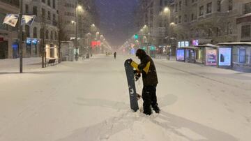 Una persona con su tabla de snowboard en la Gran Vía