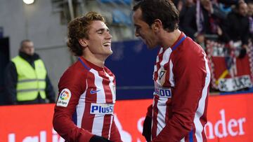 Atletico Madrid's French forward Antoine Griezmann (L) is congratulated by teammate Uruguayan defender Diego Godin after scoring his team's second goal during the Spanish league football match SD Eibar vs Club Atletico de Madrid at the Ipurua stadium in Eibar on January 7, 2017. / AFP PHOTO / ANDER GILLENEA