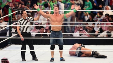 John Cena (C) celebrates defeating Triple H (R) during the World Wrestling Entertainment (WWE) Greatest Royal Rumble event in the Saudi coastal city of Jeddah on April 27, 2018. / AFP PHOTO / STRINGER