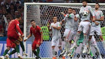Portugal's forward Cristiano Ronaldo (L) shoots to score his thrird goal during the Russia 2018 World Cup Group B football match between Portugal and Spain at the Fisht Stadium in Sochi on June 15, 2018. / AFP PHOTO / Nelson Almeida / RESTRICTED TO EDITORIAL USE - NO MOBILE PUSH ALERTS/DOWNLOADS