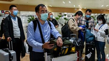 Foreign passengers wearing face masks as a protection against the coronavirus disease (COVID-19) line up to present their documents, at the Ninoy Aquino International Airport, in Pasay City, Metro Manila, Philippines, February 10, 2022. REUTERS/Lisa Marie David
