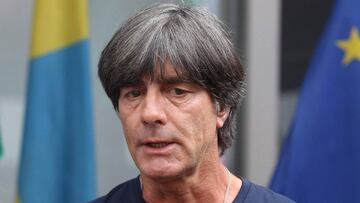 Germany's national football team head coach Joachim Loew talks to media as he arrives at Frankfurt international