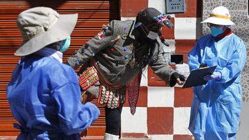 A person dressed as a Kusillo, a traditional Andean harlequin, reminds people to wear face masks, gloves and maintain the social distance as a preventive measure against the novel coronavirus COVID-19 in Puno, Peru, on May 15, 2020. - Kusillos are present