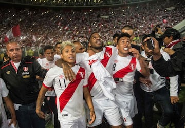 Peru's Raul Ruidiaz (L), Jefferson Farfan (C) and Christian Cueva celebrate after defeating New Zealand by 2-0 and qualifying for the 2018 football World Cup, in Lima, Peru, on November 15, 2017. / AFP PHOTO / ERNESTO BENAVIDES