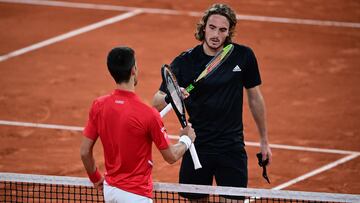 Novak Djokovic y Stefanos Tsitsipas chocan sus raquetas tras su partido de semifinales de Roland Garros 2020.