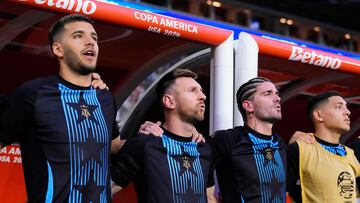 MIAMI GARDENS, FLORIDA - JUNE 29: (L-R) Valentin Carboni, Lionel Messi, and Rodrigo De Paul of Argentina sing the national anthem from the bench prior to the CONMEBOL Copa America 2024 Group A match between Argentina and Peru at Hard Rock Stadium on June 29, 2024 in Miami Gardens, Florida.   Rich Storry/Getty Images/AFP (Photo by Rich Storry / GETTY IMAGES NORTH AMERICA / Getty Images via AFP)