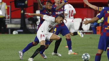 Barcelona's Arturo Vidal, left, vies for the ball with Sevilla's Joan Jordan, front, during the Spanish La Liga soccer match between Sevilla and FC Barcelona at the Ramon Sanchez-Pizjuan stadium in Seville, Spain, Friday, June 19, 2020. (AP Phot
