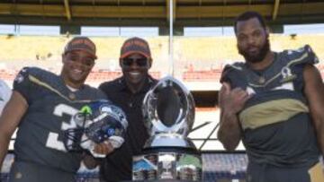 Russell Wilson, Michael Irvin y Michael Bennett posan con el trofeo del Pro Bowl.