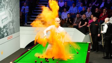 Un activista de Just Stop Oil echa polvos naranjas sobre la mesa durante los Mundiales de Snooker en el Crucible Theatre de Sheffield.