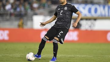 El defensa Néstor Araújo golpea el balón durante un partido de la selección mexicana de fútbol.