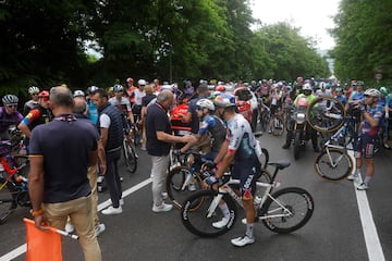 Los ciclistas conversan con los oficiales despu¨¦s de que la carrera se detuviera debido a varios accidentes durante la sexta etapa.
