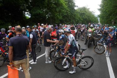 Los ciclistas conversan con los oficiales después de que la carrera se detuviera debido a varios accidentes durante la sexta etapa. 