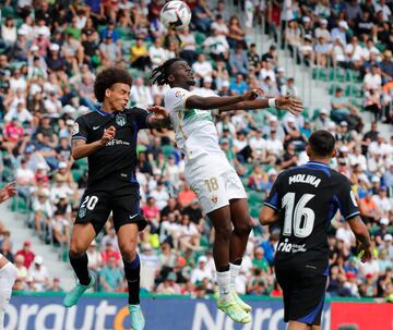 El jugador del Atleti, Witsel y el jugador del Elche, Nteka, saltan de cabeza para controlar el balón.