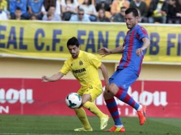 El centrocampista mexicano del Villarreal Jonathan Espericueta lucha un balón con el defensa griego del Levante Loukas Vyntra, en el partido de la trigésima tercera jornada de liga de Primera División disputado esta tarde en el estadio de El Madrigal. 