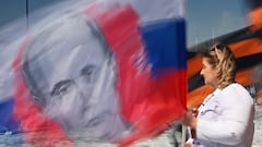 A woman carries a flag with a portrait of Russian President Vladimir Putin during celebrations of International Workers' Day in Omsk, Russia May 1, 2023. REUTERS/Alexey Malgavko