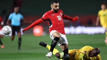 Egypt's forward #10 Mohamed Salah and Zimbabwe's defender #02 Gerald Takwara compete for the ball during the Africa Cup of Nations (CAN) group B football match between Egypt and Zimbabwe at Adrar Stadium in Agadir on December 22, 2025. (Photo by FRANCK FIFE / AFP)
