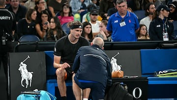 Germany's Alexander Zverev (L) is being attended by a trainer during his men's singles match against France's Alexandre Muller on day four of the Australian Open tennis tournament in Melbourne on January 21, 2026. (Photo by Paul Crock / AFP) / -- IMAGE RESTRICTED TO EDITORIAL USE - STRICTLY NO COMMERCIAL USE --