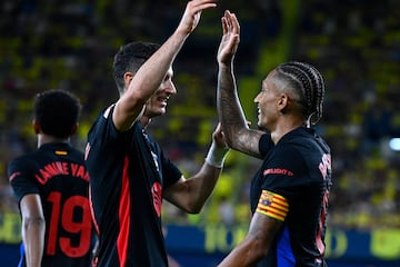 Barcelona's Brazilian forward #11 Raphinha celebrates with Barcelona's Polish forward #09 Robert Lewandowski after scoring his team's fifth goal during the Spanish league football match between Villarreal CF and FC Barcelona at La Ceramica stadium in Vila-real, on September 22, 2024. (Photo by JOSE JORDAN / AFP)