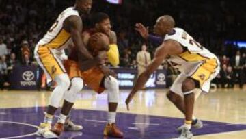 Kobe Bryant y Julius Randle tratan de robarle el balón a Paul George.