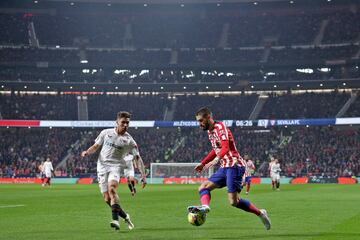 El delantero del Atlético, Yannick Carrasco, avanza con el balón ante el defensa del Sevilla, Gonzálo Montiel.