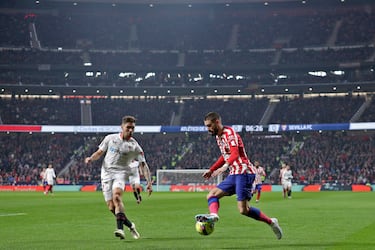 El delantero del Atlético, Yannick Carrasco, avanza con el balón ante el defensa del Sevilla, Gonzálo Montiel.