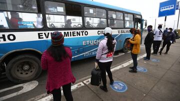 Un grupo de personas mantienen las distancias sociales mientras esperan en una parada de autob&uacute;s de Lima, Per&uacute;.