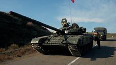 FILE PHOTO: A service member of the Russian peacekeeping troops stands next to a tank near the border with Armenia, following the signing of a deal to end the military conflict between Azerbaijan and ethnic Armenian forces, in the region of Nagorno-Karabakh, November 10, 2020. REUTERS/Francesco Brembati/File Photo